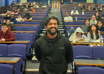 A man stands in a lecture theatre