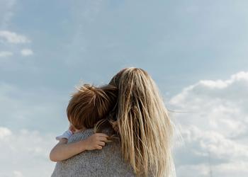 A woman with long hair holds a child