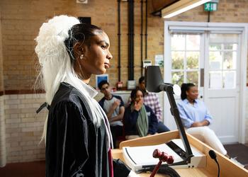 A judge listens in a mock student courtroom