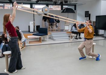 Two people interact with a roller in a studio