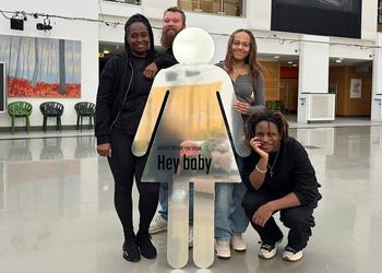 Four students standing with props from their awareness campaign