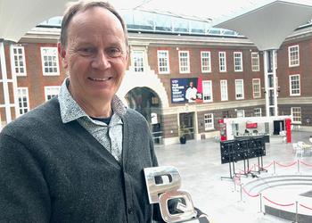A man with an award in an atrium