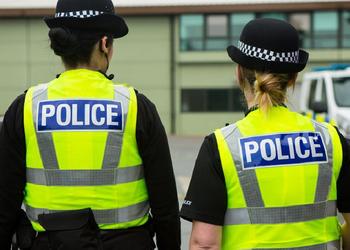 Two police officers standing side by side, wearing uniforms and looking alert.
