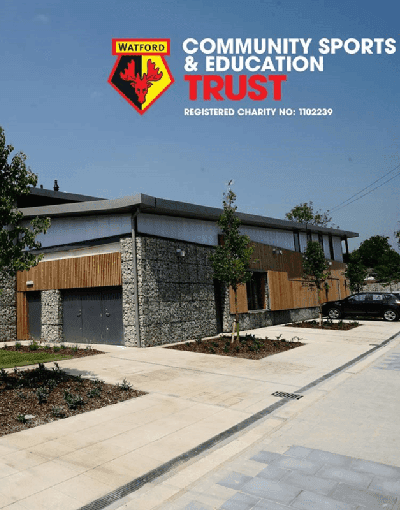 modern building made from stone and wood, with Watford FC Community Sports and Education Trust logo
