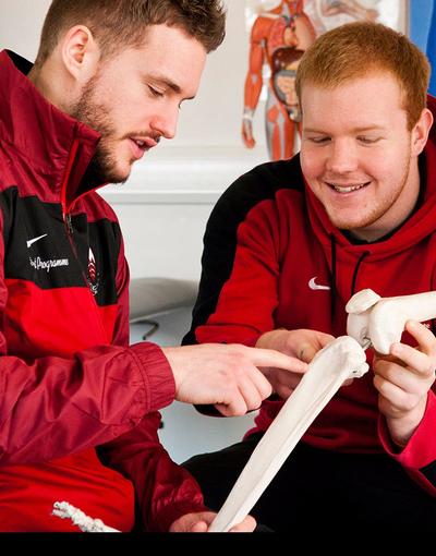 two students examining a skeleton