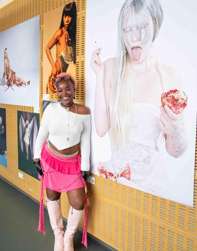 An artist poses in front of her work at an art exhibition
