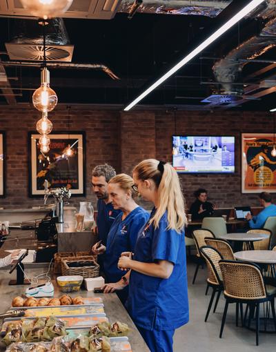A diverse group of individuals gathered around a table filled with delicious food, engaging in conversation and enjoying each other's company.
