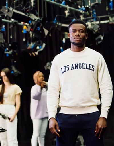 A man standing in front of a film set where a scene is being shot