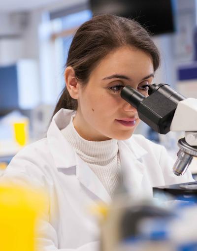 A student looking into a microscope