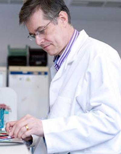 A bioengineer in a lab coat meticulously works on electronics, combining the fields of biology and engineering for scientific advancements.