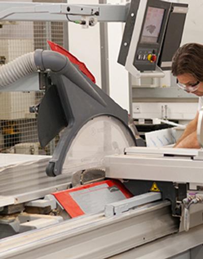 A female engineer operating machinery in a factory setting.