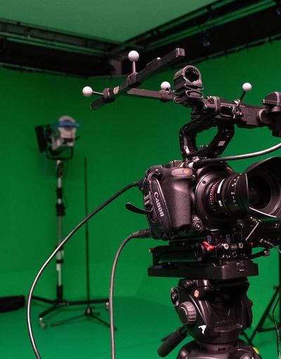 Camera in foreground with green screen behind