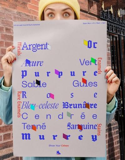 Someone holding up a sheet of a graphic design project, showing brand names in different blue fonts