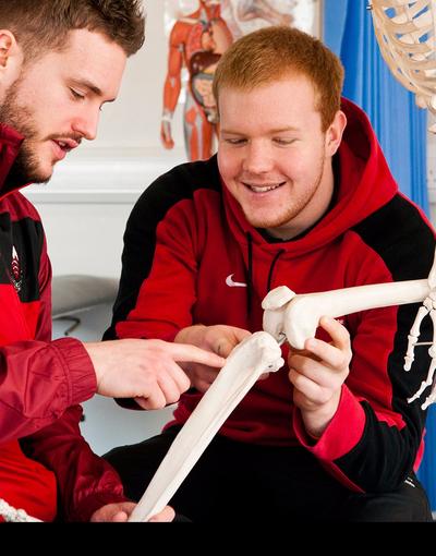 two students examining a skeleton