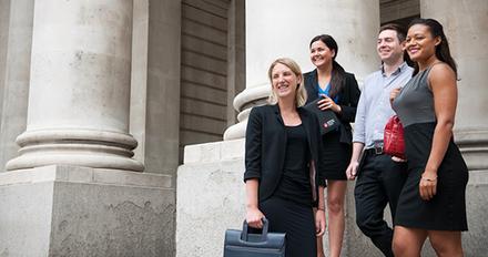 A diverse group of business professionals standing outside a modern building.