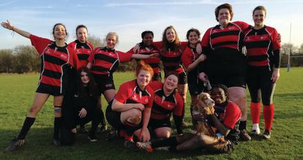 A group of women wearing red and black rugby uniforms, ready to compete in a match.