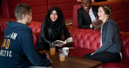 4 students chatting  in a sitting area - there's never a reason to miss out on something happening on campus