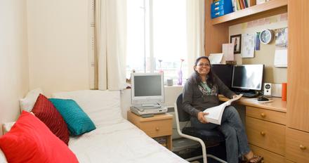 female student reading in her room at Platt Hall