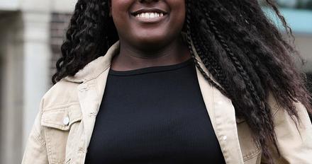 Peace - clearing student stood in front of gallery of work