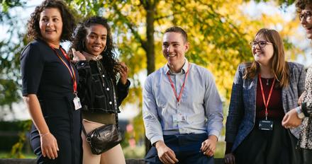 Staff outside Grove building having a chat and laughing