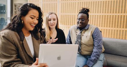 Three students looking happy chatting