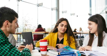 Three Business students working in a cafe