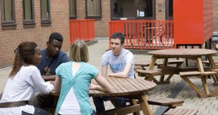 4 students chatting at a table in the courtyard at ivy hall middlesex university