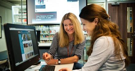 Student using computer help from library support