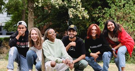 A group of young people smiling and posing together for a photograph, capturing a moment of camaraderie and friendship.