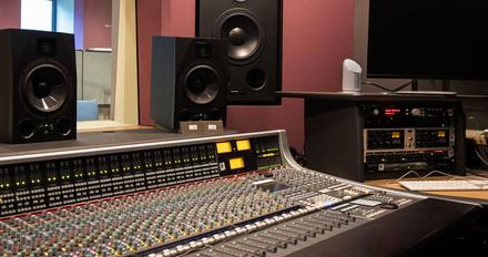 Music production set up alongside speakers and headphones