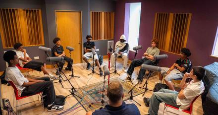A group of male teenage students record a podcast as part of a project