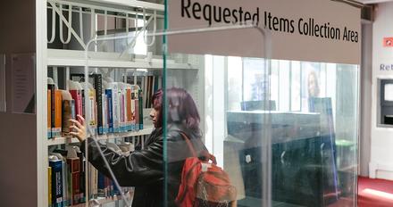 Student collecting book from requested book service