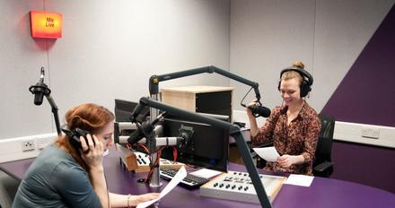 Two female students sitting in a radio studio