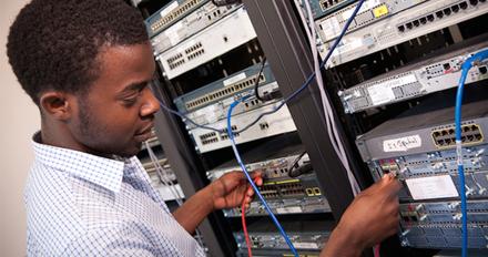 A man plugging a cable into a device