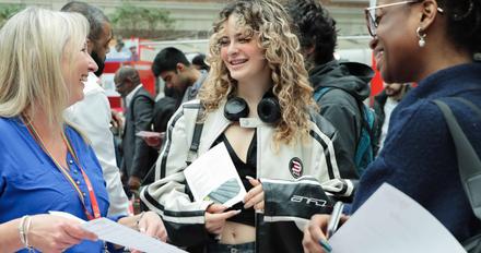 Three women engaged in conversation, exchanging information and networking.