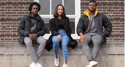 three students pose on campus, they look determined