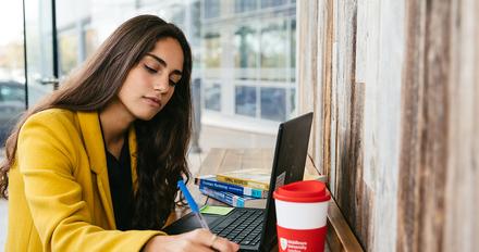 student making notes at desk