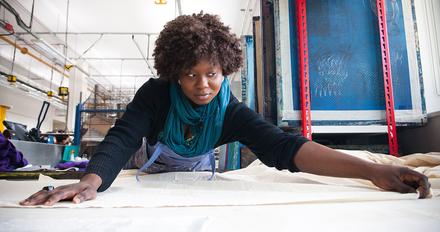 Student stretches large sheet ready to be printed