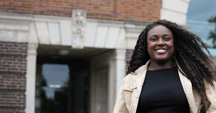 Peace - clearing student stood in front of gallery of work