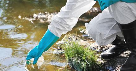 Student taking water samples from a river