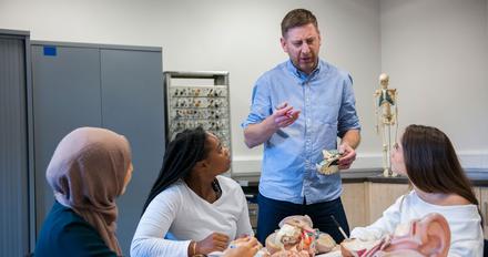 Psychology tutor talks to a group of students.