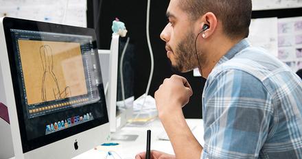 student sits working at large computer
