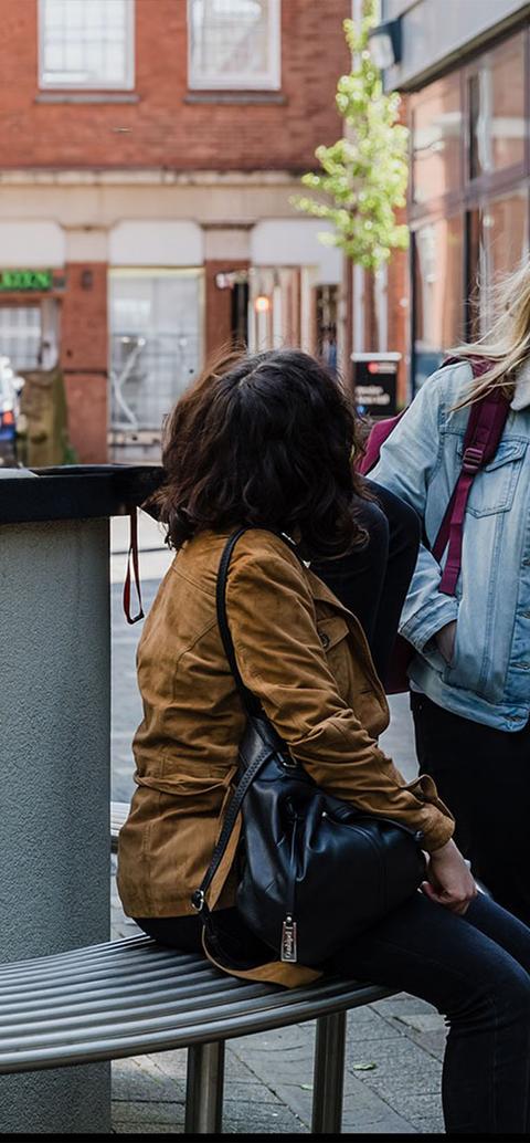 two girls walk along chatting outside middlesex university