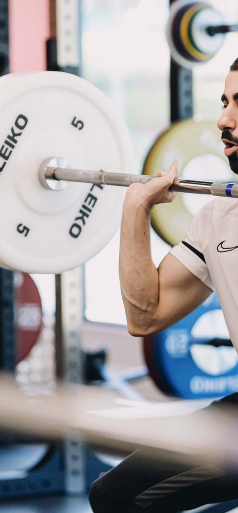 A student lifting weights at the gym in the West Stand