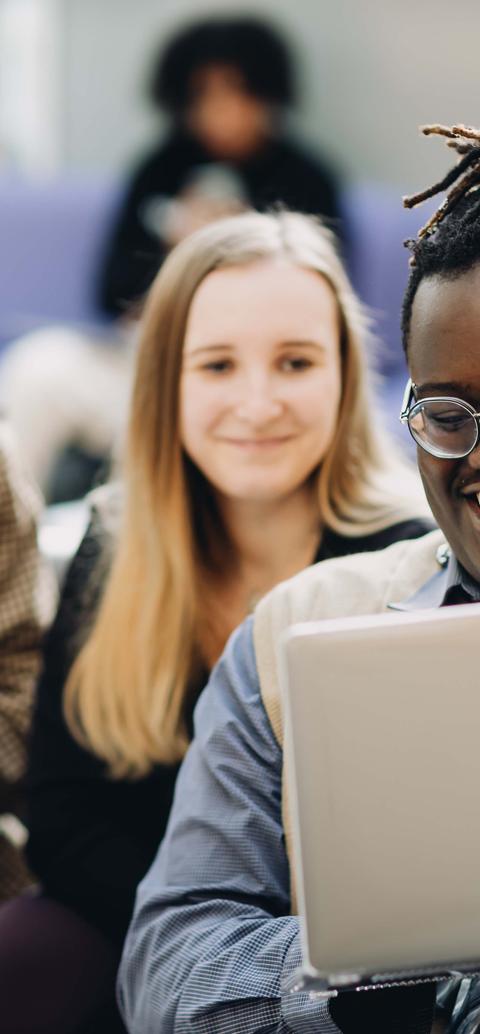 Three students looking at a laptop