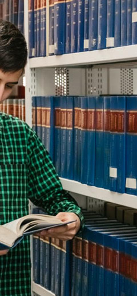 Male law student reading book in library