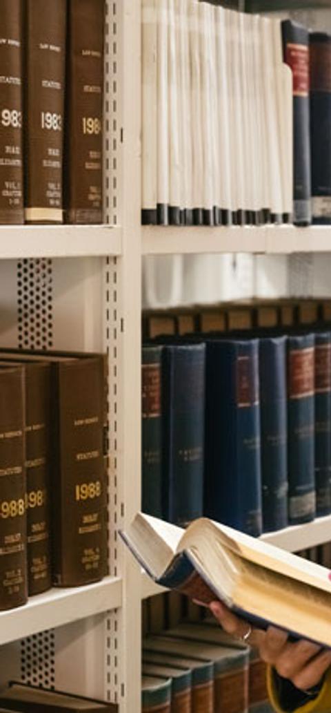 Female law student reading book in library