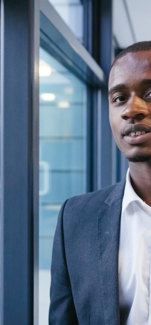 A headshot of a man dressed business casual standing in Grove Building