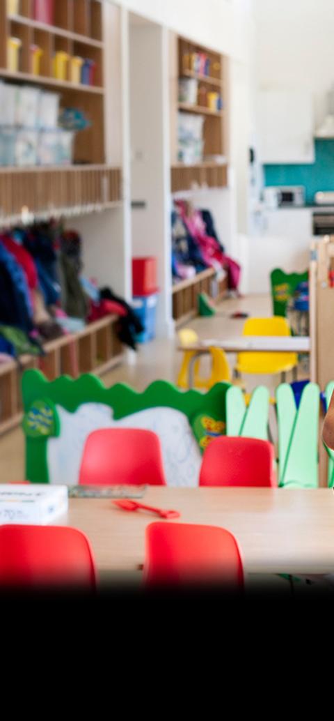 girl in blue top standing cross armed in class room