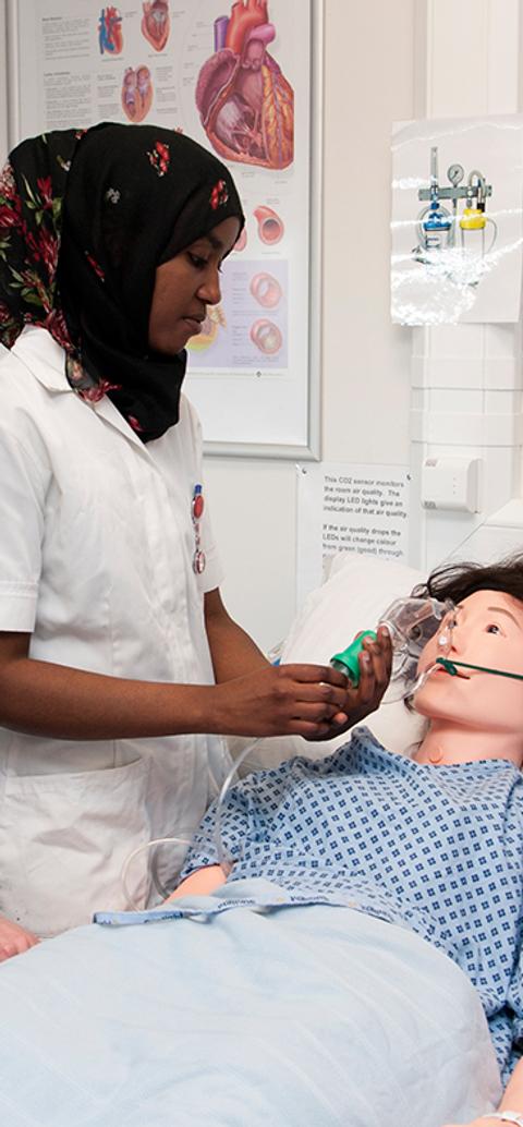 student nurses examining a dummy in class